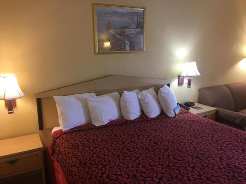 a hotel room with a bed with white pillows at Days Inn by Wyndham Yazoo City in Yazoo City