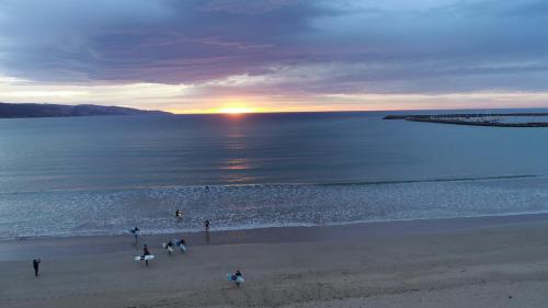 a group of people walking on the beach at sunset at BIG4 Apollo Bay Pisces Holiday Park in Apollo Bay