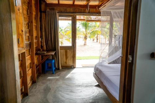 a bedroom with a bed and an open door at Whisky Point Resort in Arugam Bay