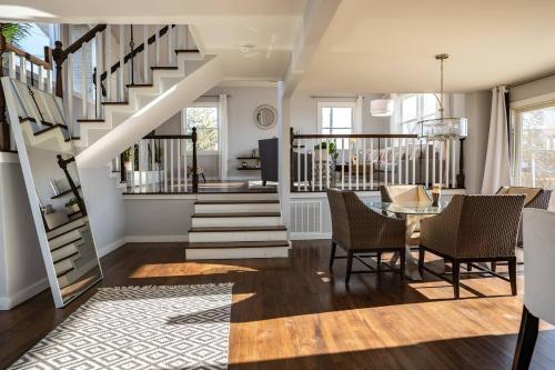 a living room with a staircase and a table and chairs at Modern Luxury Family Getaway Near Beach Casinos in Atlantic City