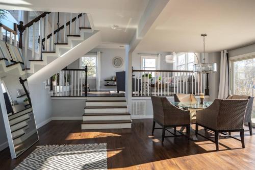 a living room with a staircase and a table and chairs at Modern Luxury Family Getaway Near Beach Casinos in Atlantic City