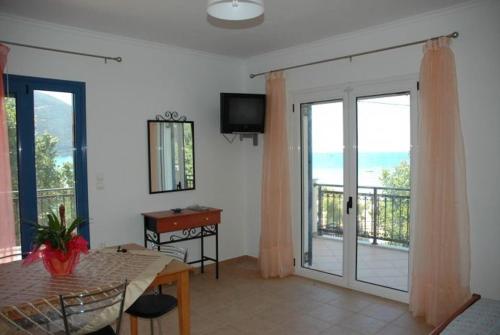 a living room with a table and a sliding glass door at Maistrali in Vasiliki