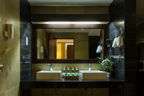 a bathroom with two sinks and a large mirror at Grand Udawalawe Safari Resort in Udawalawe