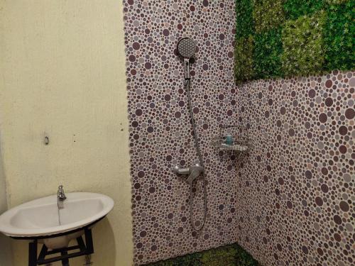 een badkamer met een douche en een wastafel bij De Hanami Homestay @Sapphire in Cirebon