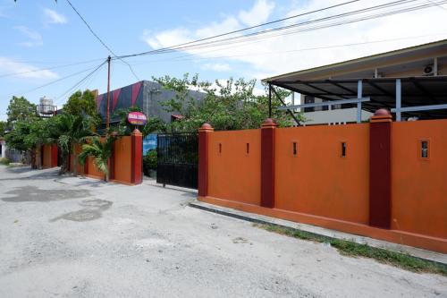an orange fence on the side of a street at RedDoorz near Mutiara SIS Al Jufrie Airport Palu in Palu