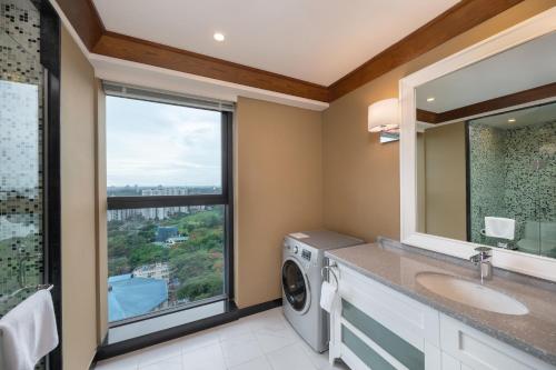 a bathroom with a washing machine and a window at Kantharyar Serviced Apartment in Yangon