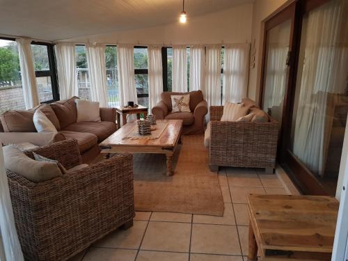 a living room with couches and a coffee table at Bushys Oak in Bushmans River Village