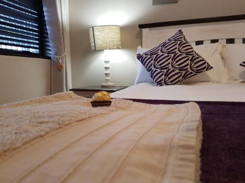 a bedroom with a bed and a lamp on a table at Bushys Oak in Bushmans River Village