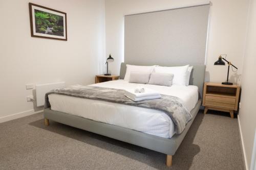 a bedroom with a bed with white sheets and pillows at All Seasons Marysville in Marysville