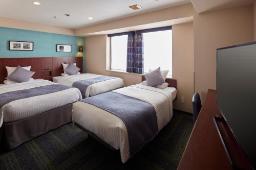 Giường trong phòng chung tại HOTEL MYSTAYS Yokohama
