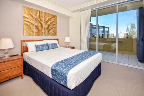 sypialnia z łóżkiem i dużym oknem w obiekcie Pumicestone Blue Resort w mieście Caloundra