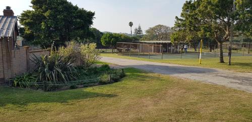 a park with a tennis court in the distance at Bushys Oak in Bushmans River Village