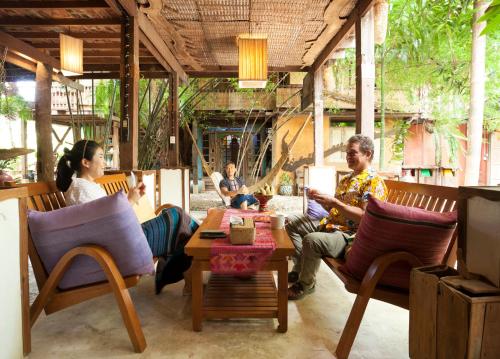 a group of people sitting at a table in a restaurant at BaanBooLoo Village in Chiang Mai