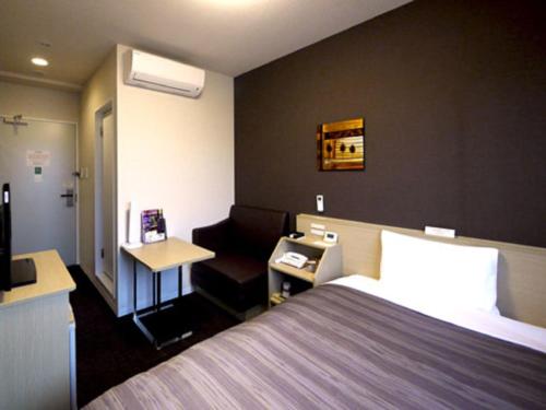 מיטה או מיטות בחדר ב-Hotel Route-Inn Iwakiizumi Ekimae