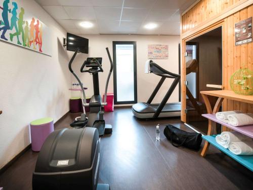 a gym with treadmills and exercise bikes in a room at ibis Styles Montbéliard in Montbéliard