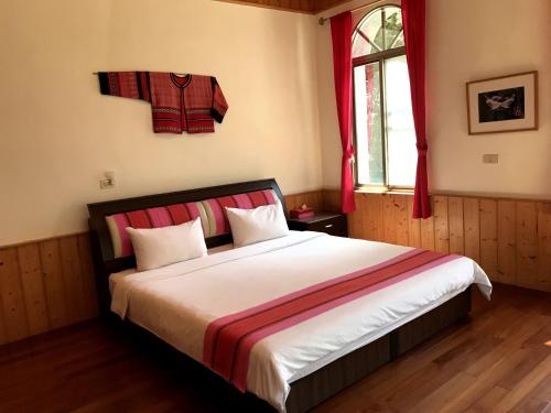 a bedroom with a large bed with red curtains and a window at Raisinay in Nanzhuang