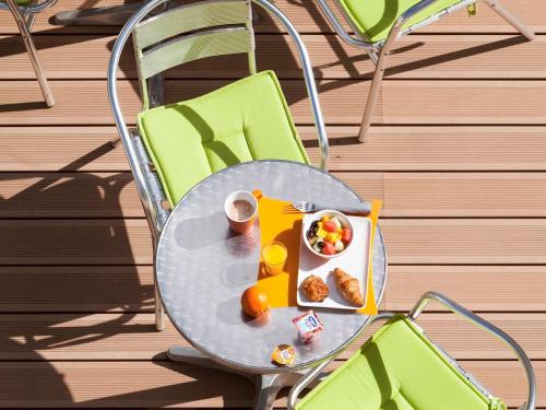 a table with a plate of food and a bowl of fruit at ibis Styles Saumur Gare Centre in Saumur