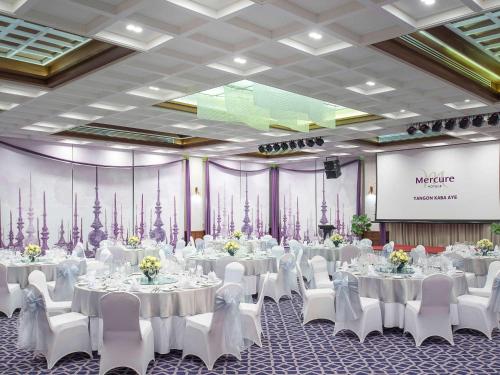 a banquet hall with white tables and white chairs at Mercure Yangon Kaba Aye in Yangon