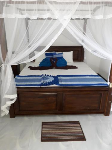 a bedroom with a bed with a canopy at The Wave's Guest House in Mirissa