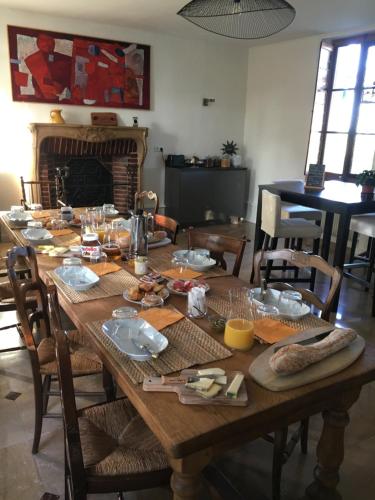 a wooden table with food on it in a room at L'evidence in Bragny-sur-Saône