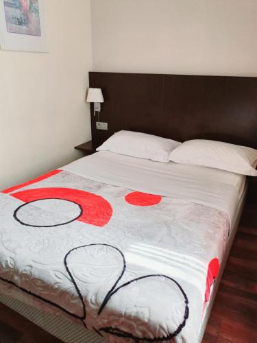 a large bed with red flowers on it at Hotel Queen Mary in Brussels