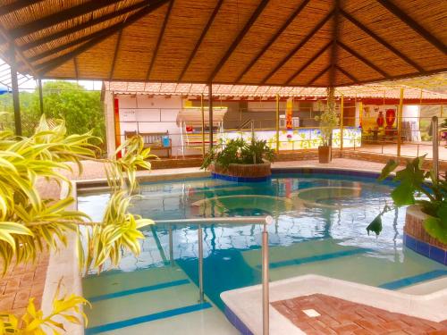a large swimming pool with blue water in a building at Hotel Spa Casa de Adobe Villa de Leyva in Villa de Leyva