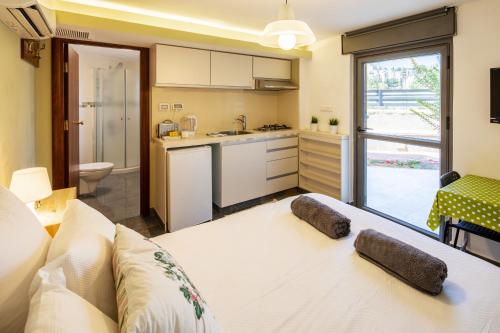 a living room with a white couch and a kitchen at Quiet Apartments in Beit Safafa- Jerusalem in Jerusalem