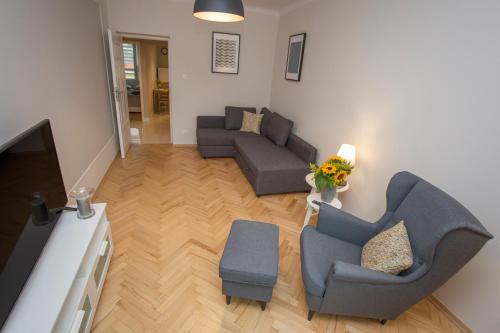 ein Wohnzimmer mit 2 Sofas und einem TV in der Unterkunft CR Apartament w Centrum Lipowa 18 in Białystok