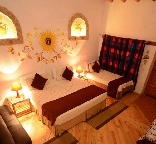 a small bedroom with two beds and a couch at Hotel Spa Casa de Adobe Villa de Leyva in Villa de Leyva