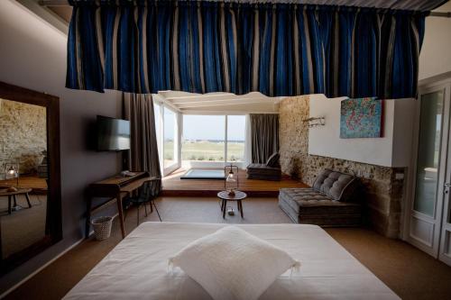 a bedroom with a large bed and a living room at Resort I Mulini in Trapani