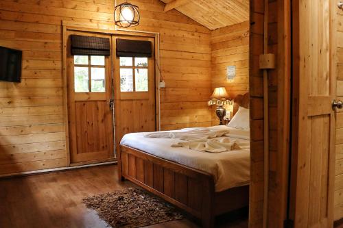 a bedroom with a bed in a log cabin at Montego Bay Beach Village - Morjim in Morjim