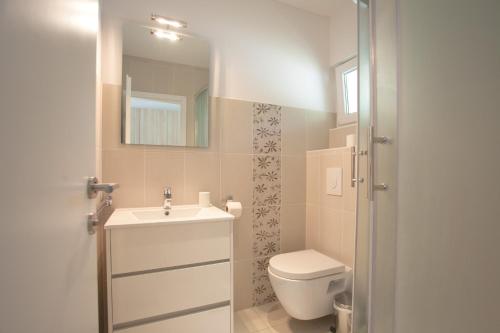 a bathroom with a toilet and a sink and a mirror at Studio apartment - seaview in Premantura