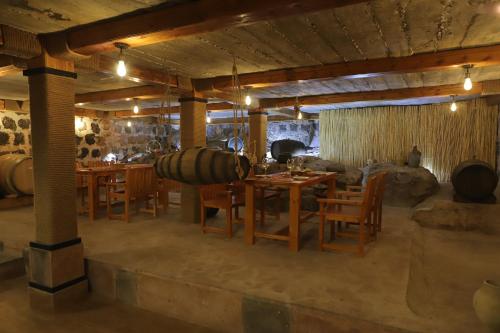 uma sala de degustação de vinhos com mesa e cadeiras em Yeganyans Guest House and Wine Yard em Ashtarak