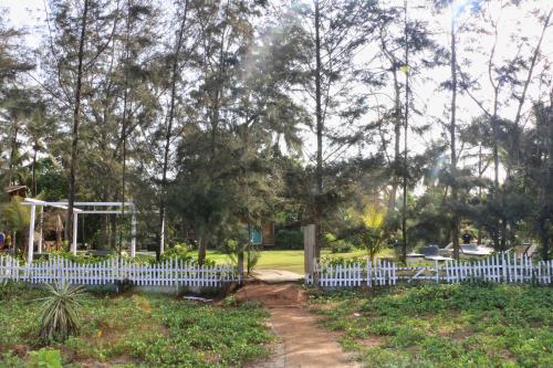 a white picket fence in a park at Montego Bay Beach Village - Morjim in Morjim