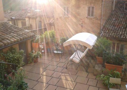 un ombrello bianco seduto su un patio sotto la pioggia di Albergo Italia a Urbino