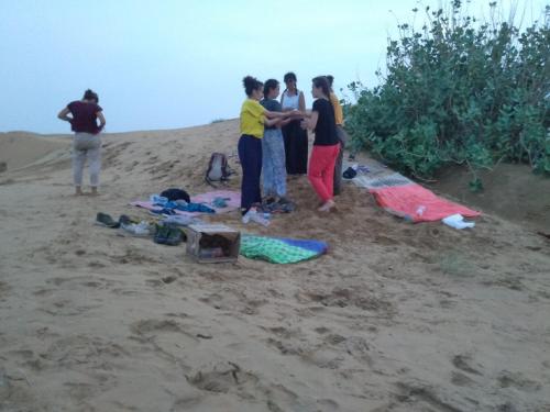a group of people standing on a beach at Bob Cafe & Guest House Jaisalmer in Jaisalmer