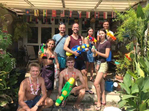 Eine Gruppe von Leuten, die sich für ein Bild in einem Hinterhof posieren in der Unterkunft Hub of Joys Hostel in Ko Lanta