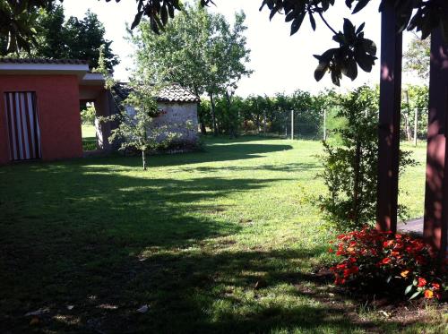 a yard with grass and flowers and a building at B&B Terre Di Bea in Pederobba