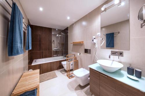 a bathroom with a sink and a toilet and a tub at maresoul - Ferienapartment mar in Raposeira