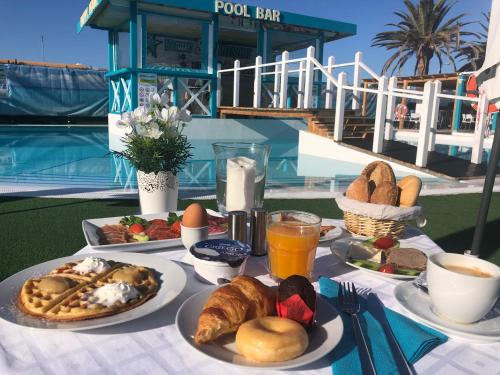 een tafel met borden met eten en drinken erop bij Venus Star Resort - FKK Nudist Swingers - Only Couples in Maspalomas