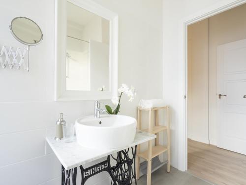 a white bathroom with a sink and a mirror at El Hotelito 27 in Santa Cruz de la Palma