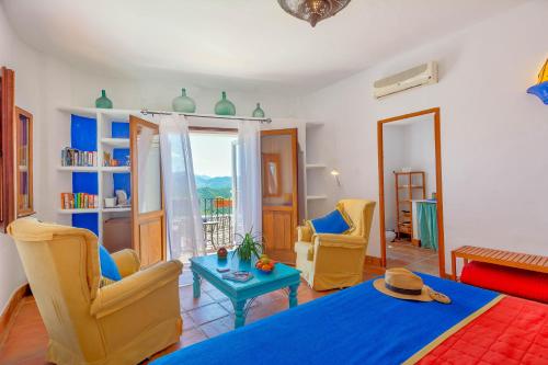 a living room with a blue bed and chairs at Hotel Los Castaños in Cartajima