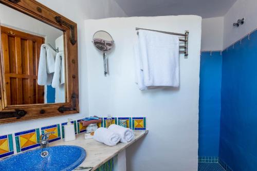 a bathroom with a blue sink and a mirror at Hotel Los Castaños in Cartajima