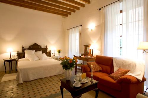 Turismo de Interior S'Ardeviu في سولير: غرفة معيشة مع سرير وأريكة