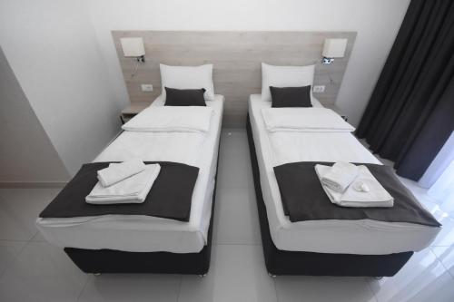 two beds in a small room withskirts at Hotel Mladost in Tjentište