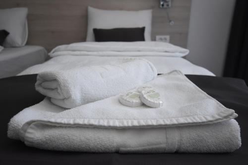 two beds with white towels and towels at Hotel Mladost in Tjentište
