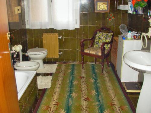 y baño con aseo, lavamanos y silla. en BED & BREAKFAST da marco en Toscolano Maderno