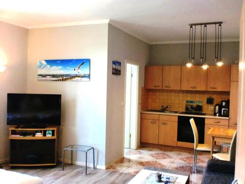 a living room with a kitchen and a dining room at Studio - Lachmoewe in Peenemünde