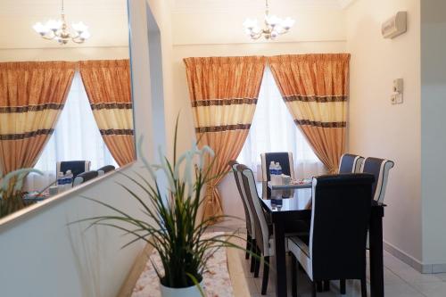 a dining room with a table and chairs and a mirror at Permai Seri Homestay in Ampang