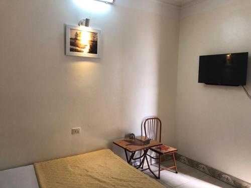 a room with a bed and a table and a tv at V A Motel in Hai Phong